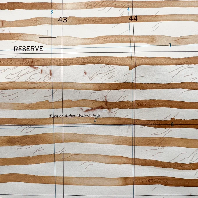 A small detail of an old topographic map with pale red ochre stripes running horizontally. Details of the original map can be seen