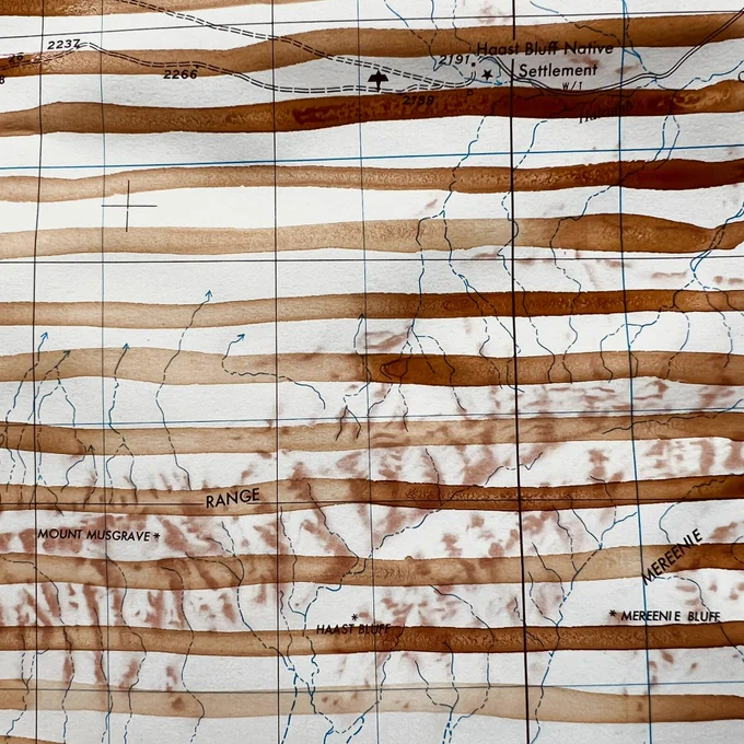 A small detail of an old topographic map with pale red ochre stripes running horizontally. Details of the original map can be seen