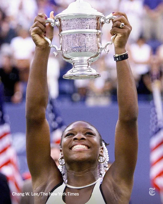 Serena Williams holds a silver trophy above her head and smiles after winning the 1999 U.S. Open. Photo credit: Chang W. Lee/The New York Times
