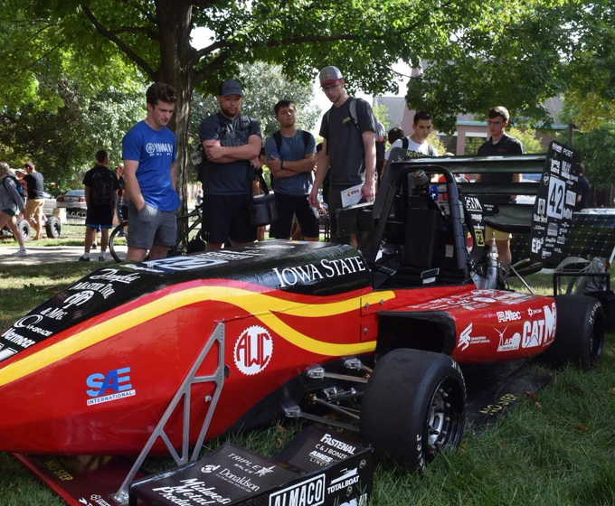 Students examine a mini Formula 1 car