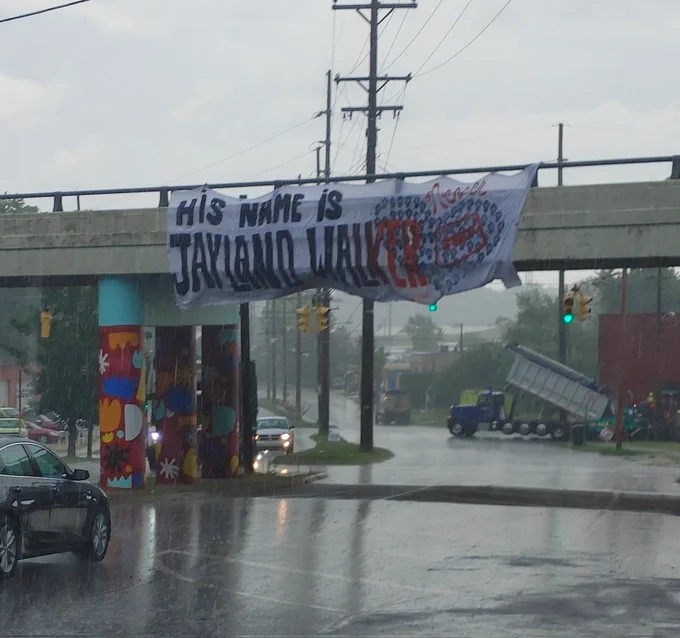Justice For Jayland Walker banner drop in Akron Ohio says "HIS NAME IS JAYLAND WALKER" 