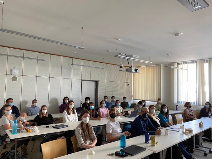 A group of people sitting in a lecture room.