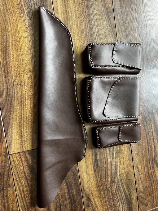 Three pouches and a quiver made of brown fauc leather side by side with off white stiching around the edges to give it a hand made look