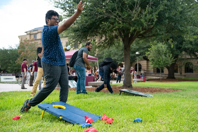 students playing cornhole on the grass in Academic Plaza.