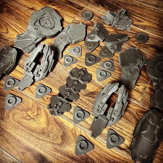 Unpainted foam armour from Aloy's Shield Weaver cosplay arranged on a wooden floor and with a filter over it