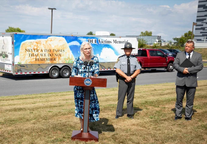 PennDOT Executive Deputy Secretary Melissa Batula stands at a podium outside in front of the DUI Victims Memorial.