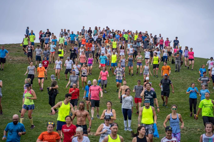 Hundreds of November Project members interacting while walking down the hill after the workout at Gasworks Park in Seattle, WA. 
