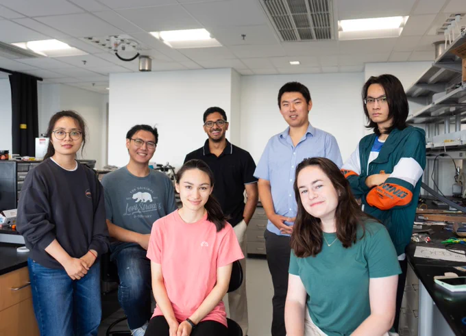 Professor Wubin Bai and his team of six fellow researchers smile for a photo in their lab.