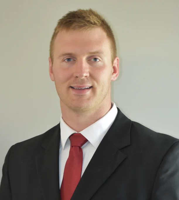 A headshot of ME assistant professor Todd Kingston. He is wearing a suit and tie. 