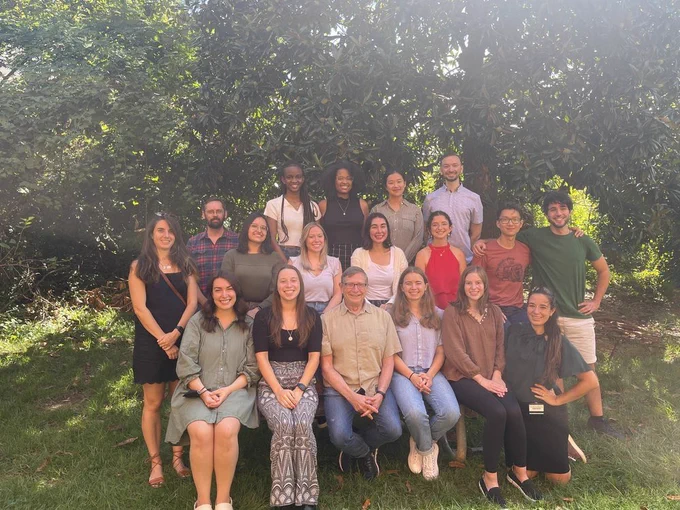 Photo of 18 people sitting outside, posing for a group picture!
