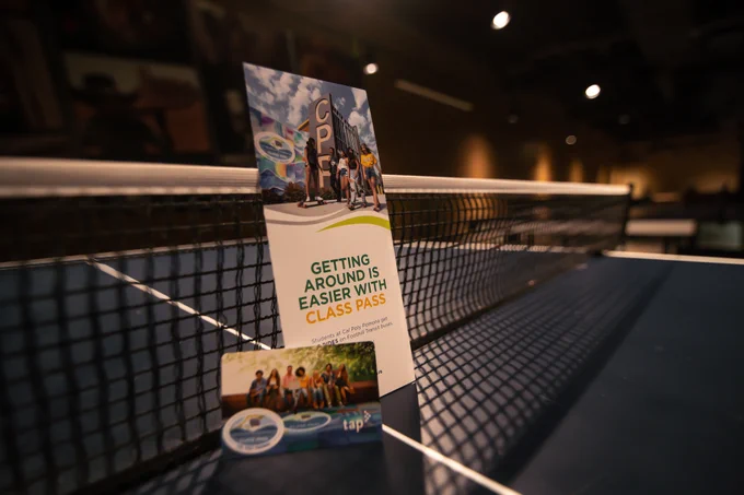 A Brochure including text "Getting Around Is Easier With Class Pass"  and a TAP card displayed on a ping-pong table.