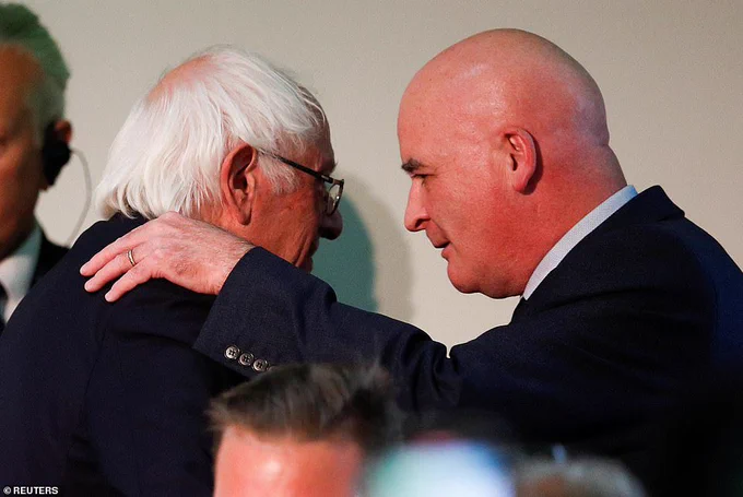 Mick Lynch and Bernie Sanders from the side with Mick putting his left hand on Bernie's shoulder.