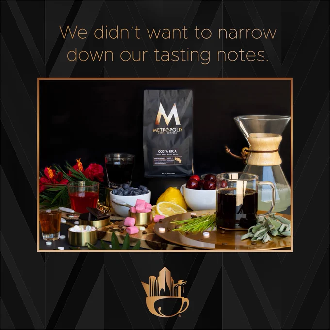 A photo of a bag of Metropolis Coffee’s Costa Rica Perla Negra Single Origin. It sits behind these tasting visuals: a glass of cherry cola, a bowl of blueberries, a shot glass of honey, a measuring cup of bubblegum, a Chemex full of lemonade, a measuring cup of sweet tarts, a bowl of cherries, fresh sage, a glass of fruit punch, fresh lemon slices, a measuring cup of chocolate bars, wild lemongrass, and hibiscus flowers.

Above the photo “We had a lot of tasting notes” is written in a gold gradient. The background is a black gradient pattern, with the Metropolis Coffee skyline & cup logo beneath the photo.

