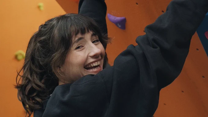 An image of someone at Folkestone 51 climbing and smiling