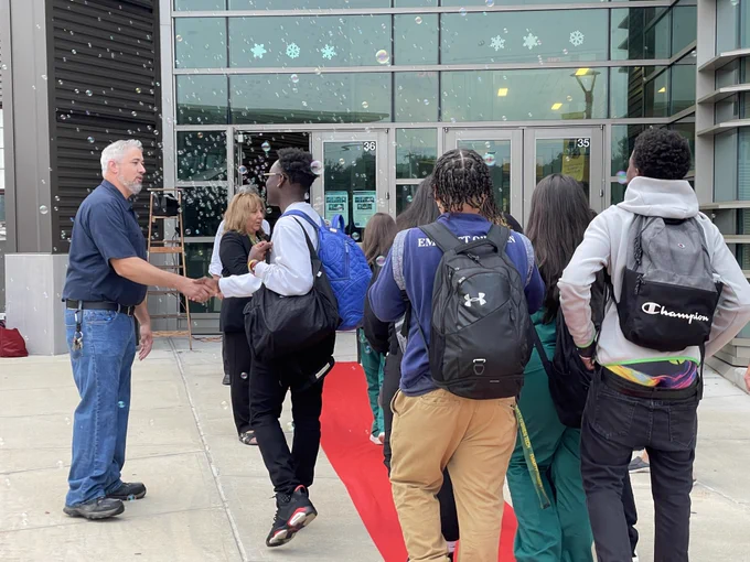 Staff and administration at Emmett O'Brien Technical High School greet students for their first day of school with a red carpet celebration. 