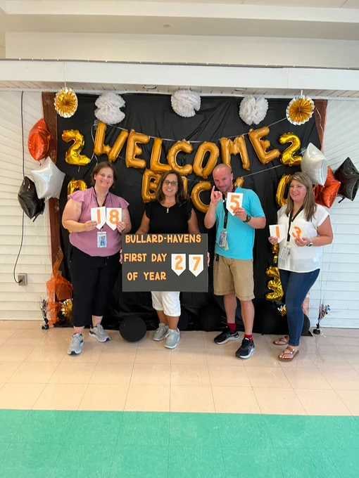 Staff and administration at Bullard-Havens Technical High School poses for a photo depicting the number of years they've been teaching. 