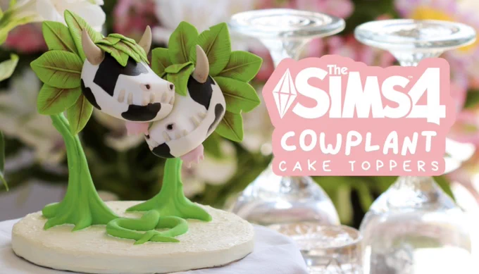 Cowplant cake toppers from the Sims 4, handmade with polymer clay. Two of them grow next to each other, nuzzling with their goofy snouts. They have large leafy manes and cowplant print faces, with big silly teeth. Totally probably safe.