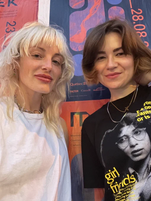 Selfie of Renee and Stefana. Renee has blonde hair, wears a white tee, Stefana has brown hair, wears a black graphic tee