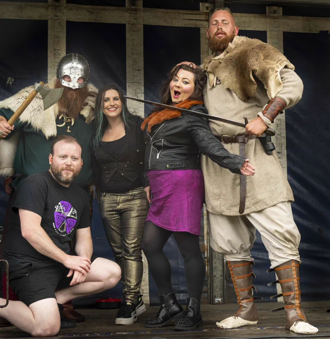 Viking warriors pose with sword and axe alongside Celtic folk rock band on stage at Largs Viking festival. Largs was the turning point of Viking fortunes in 1263ad.