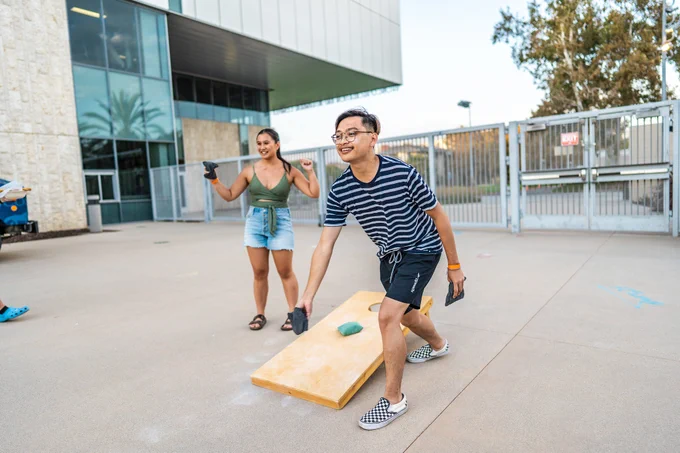 People enjoying their time playing Cornhole.