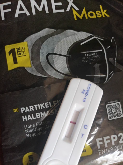 Ein negativer COVID-19 Antigen Schnelltest auf der Packung einer frischen FFP2 Maske