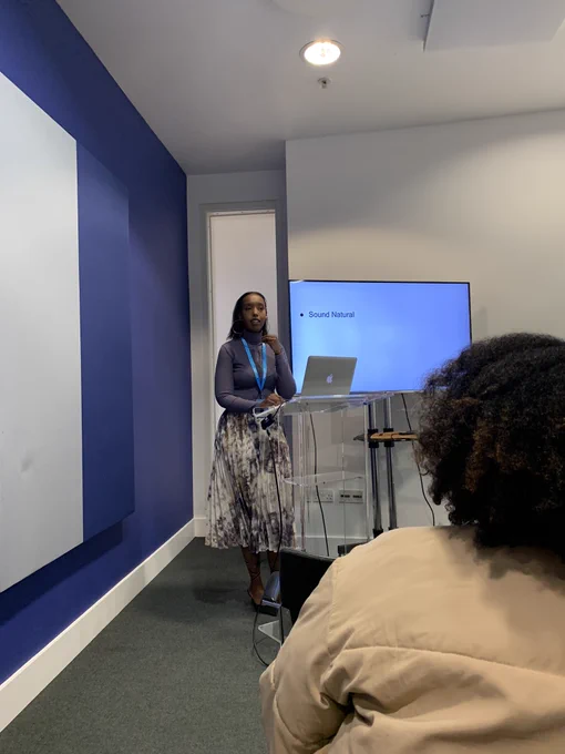 Dahaba’s talk on scripting for presenting. Dahaba is talking through a slide which says “sound natural” she has her arm raised as she demonstrates her point