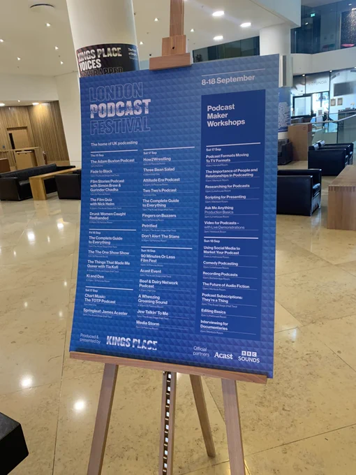 A poster for the London podcast festival and the makers weekend. It’s a blue poster with white writing and it’s stood at the entrance of kings place