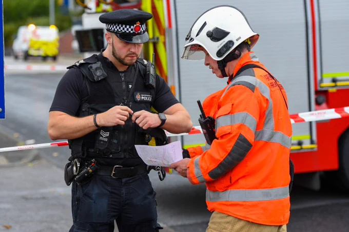 A fire officer and police sergeant liaise whilst looking at a map of the area