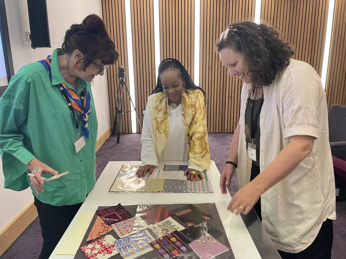 Avis Charles and members from the audience looking at textile samples