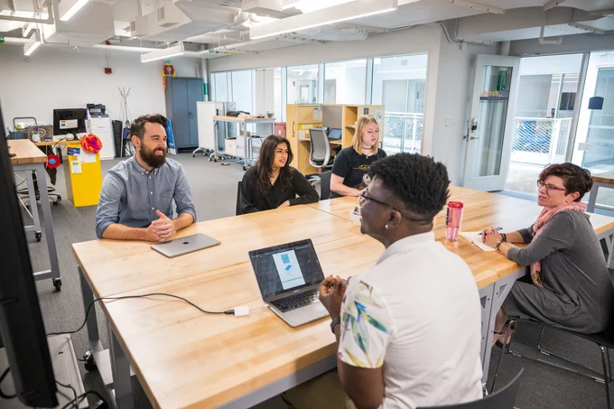Individuals work around a conference table at LaunchNet offices. 