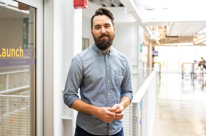 Zach Mikrut, director of LaunchNET, smiles while in the office.