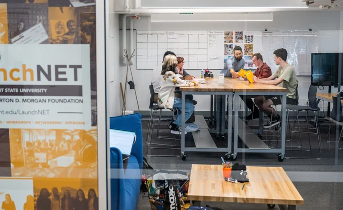 Individuals work around a conference table at the LaunchNET offices. 