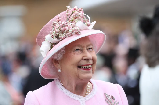 The Queen smiling wearing pink