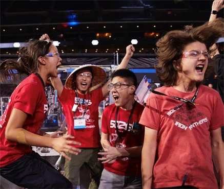 Team of excited students at a robotics competition