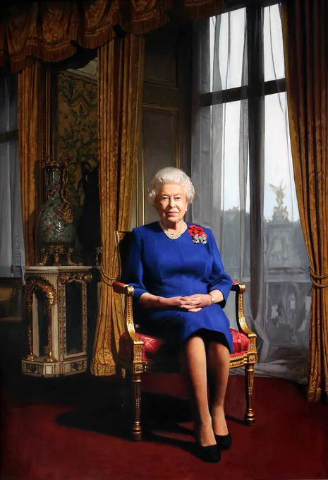 An official portrait of Her Majesty Queen Elizabeth II by Darren Baker. The Queen sits in a chair in front of a large window. She wears a blue coloured dress and has a spray of five poppies on her left shoulder. 