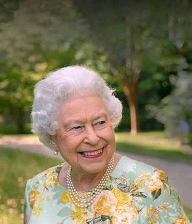 Her Majesty Queen Elizabeth Second with trees in the background.