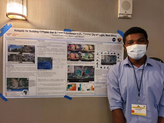 A scientist posing with their research poster