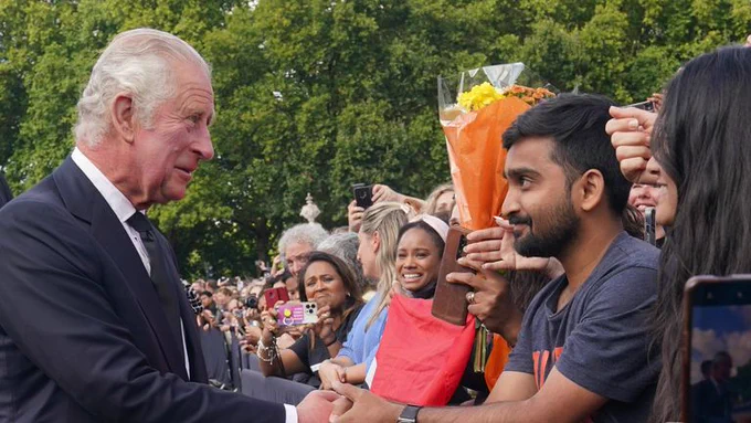 King Charles shakes hands of the assembled crowd