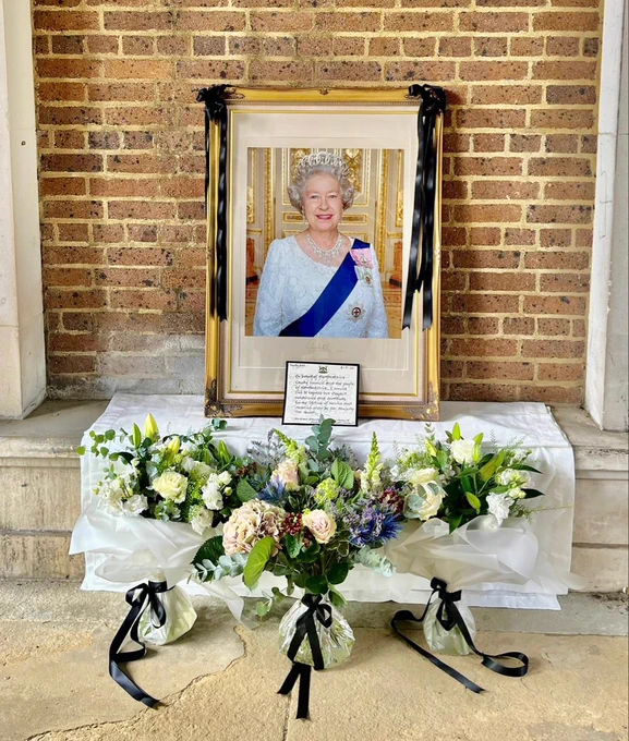 Framed picture of the Queen with flowers in front of it in the space under the arches at County Hall, Hertford