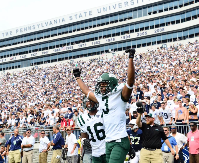 Ohio Football player wearing #3 jersey raises his arms up in celebration after scoring a touchdown at Penn State's stadium in Happy Valley, Pennsylvania.