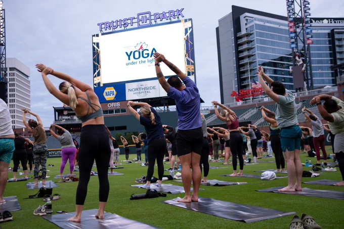 Guests stretch on the field at Truist Park during Yoga Under the Lights