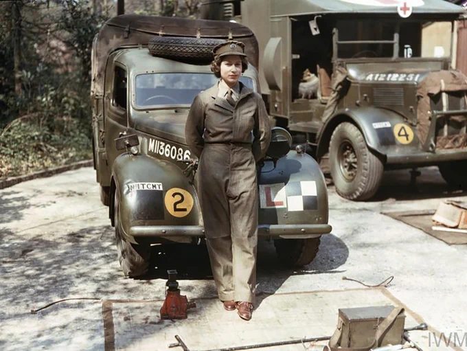 Queen Elizabeth II in her ATS uniform, standing in front of an army vehicle. Image from the Imperial War Museum collection, TR 2835.)