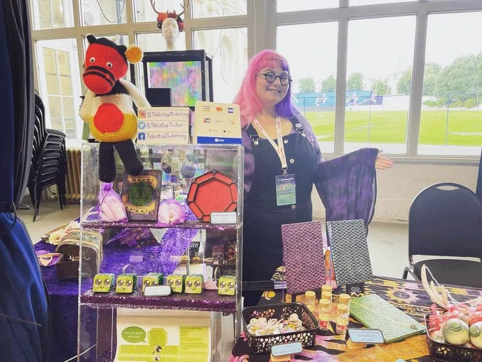 Person standing behind a table with items from previous picture 