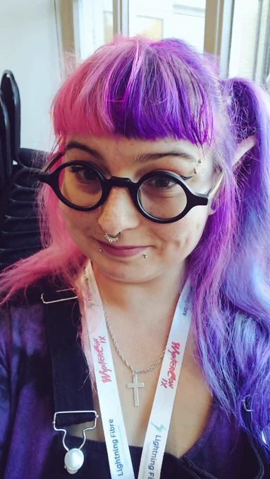 Person with round glasses and pink%purple hair