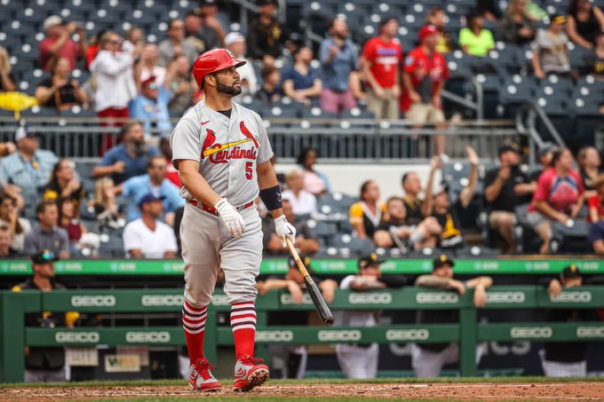 Albert Pujols holds his bat in his left hand as he walks down the first base line and watches the ball he hit leave the park for the six hundred and ninety-seventh time. 
