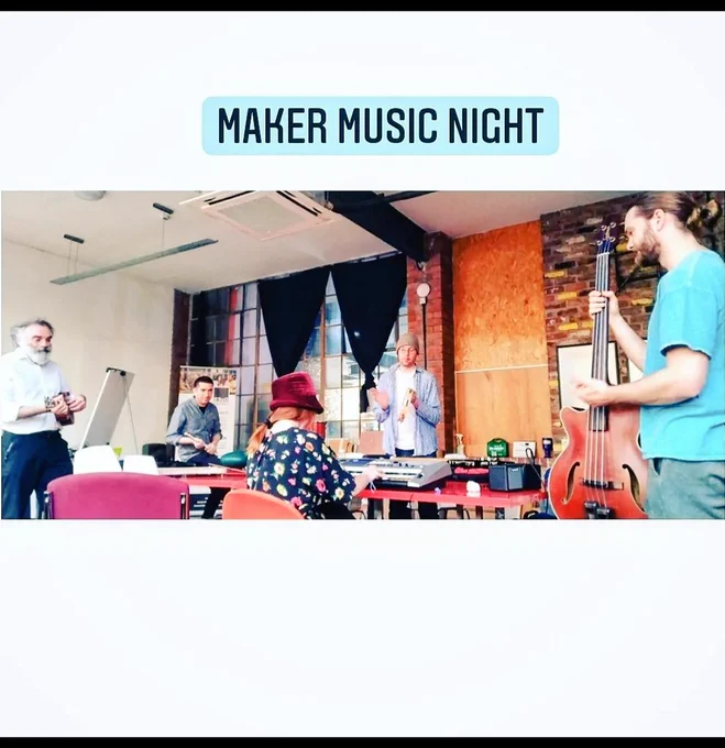 A group of people in DoES Liverpool event space playing bass, keyboard, drums, tambourine and flute 