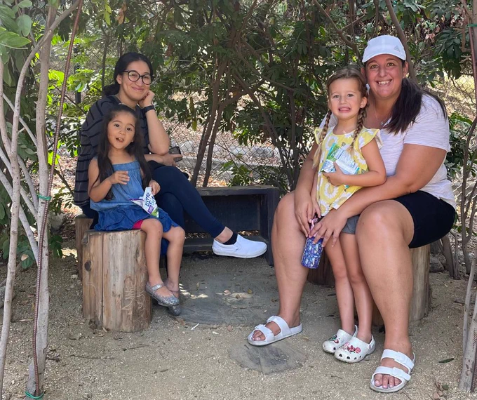 Moms and children sitting in the shade having a snack