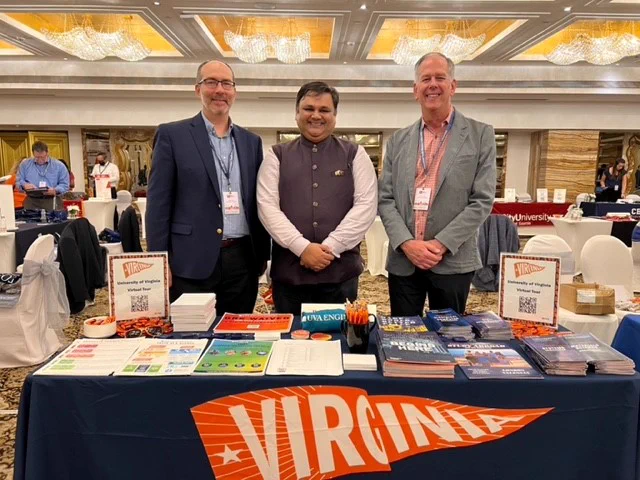 Phil Trella, Dr. Priyam Sheth and Jim Smith standing behind a table with recruiting materials