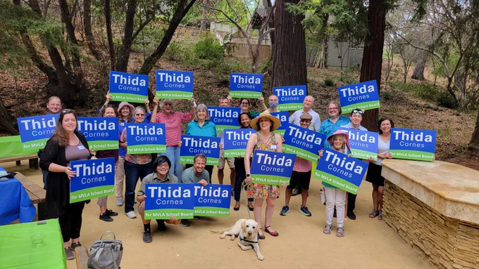 A bunch of people holding Thida Cornes for MVLA School Board signs 