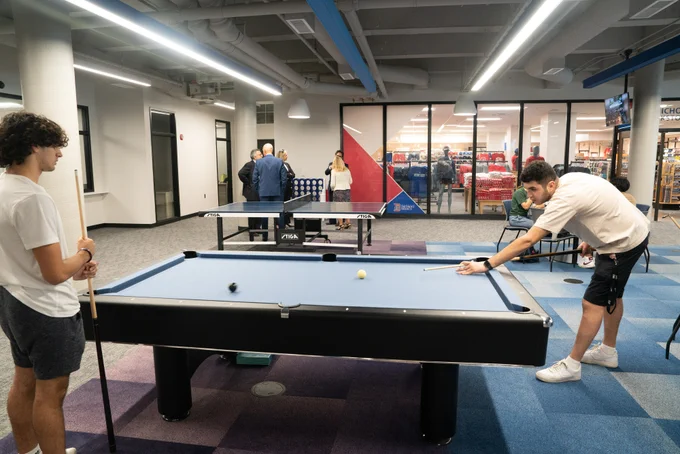 Two students playing pool inside the Student Union Center
